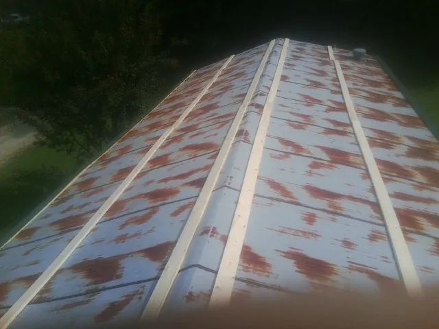 Rusted metal roof panels with new wood purlins before replacement — Storm Damage Roof Repair in Philo by Roofing Brothers