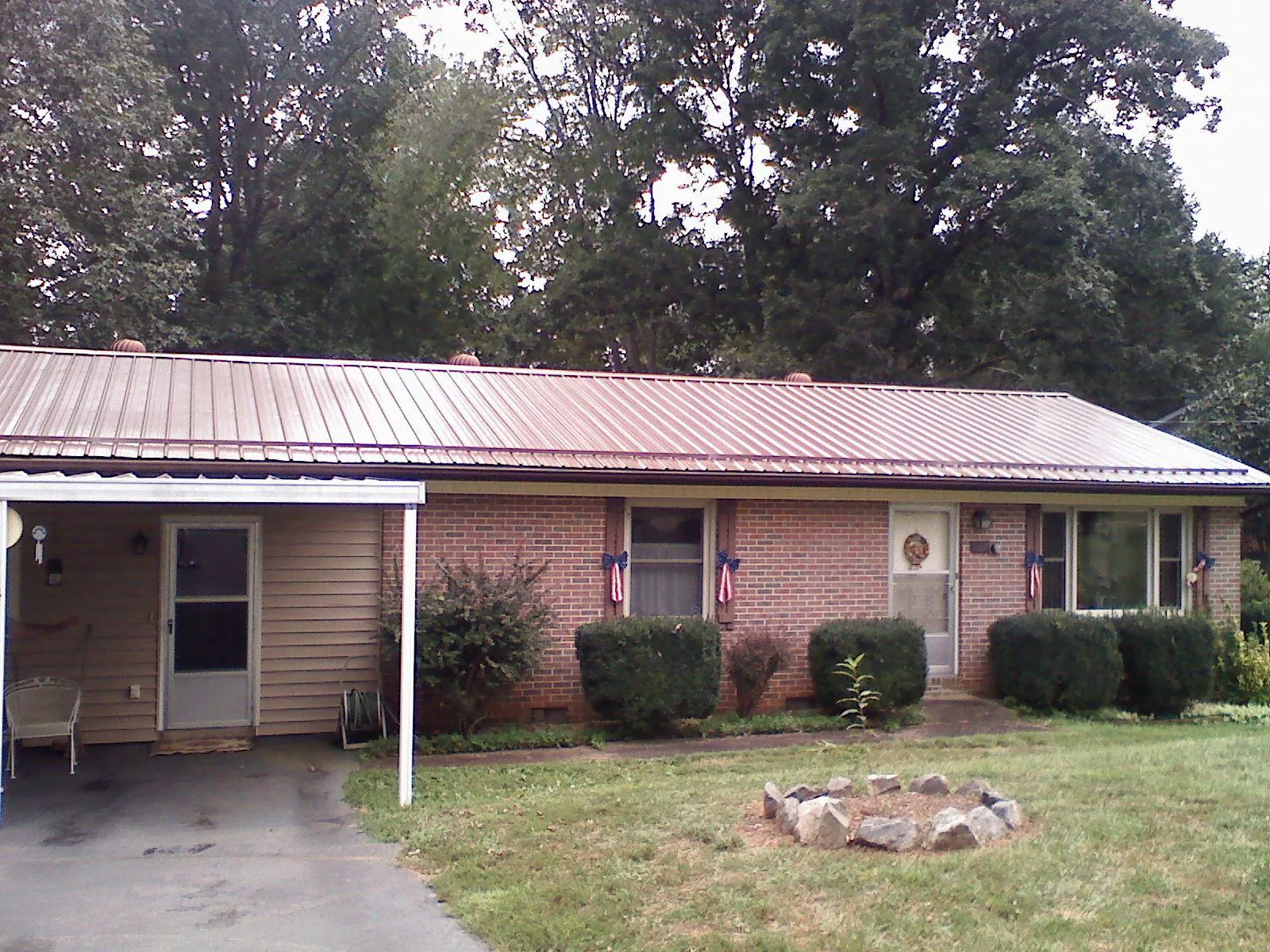 Bronze metal roof and carport on a brick ranch home — Roof Repair work by our crew in Philo