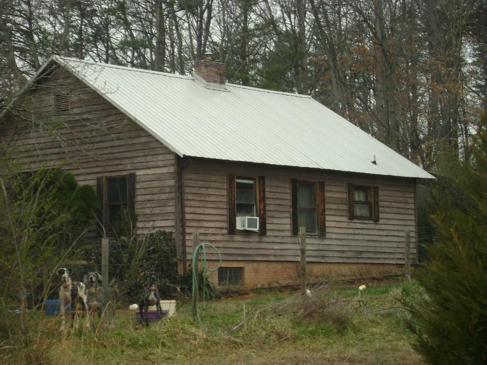 White metal roof on an old wood sided farmhouse, from a Metal Roof Installation job in Philo